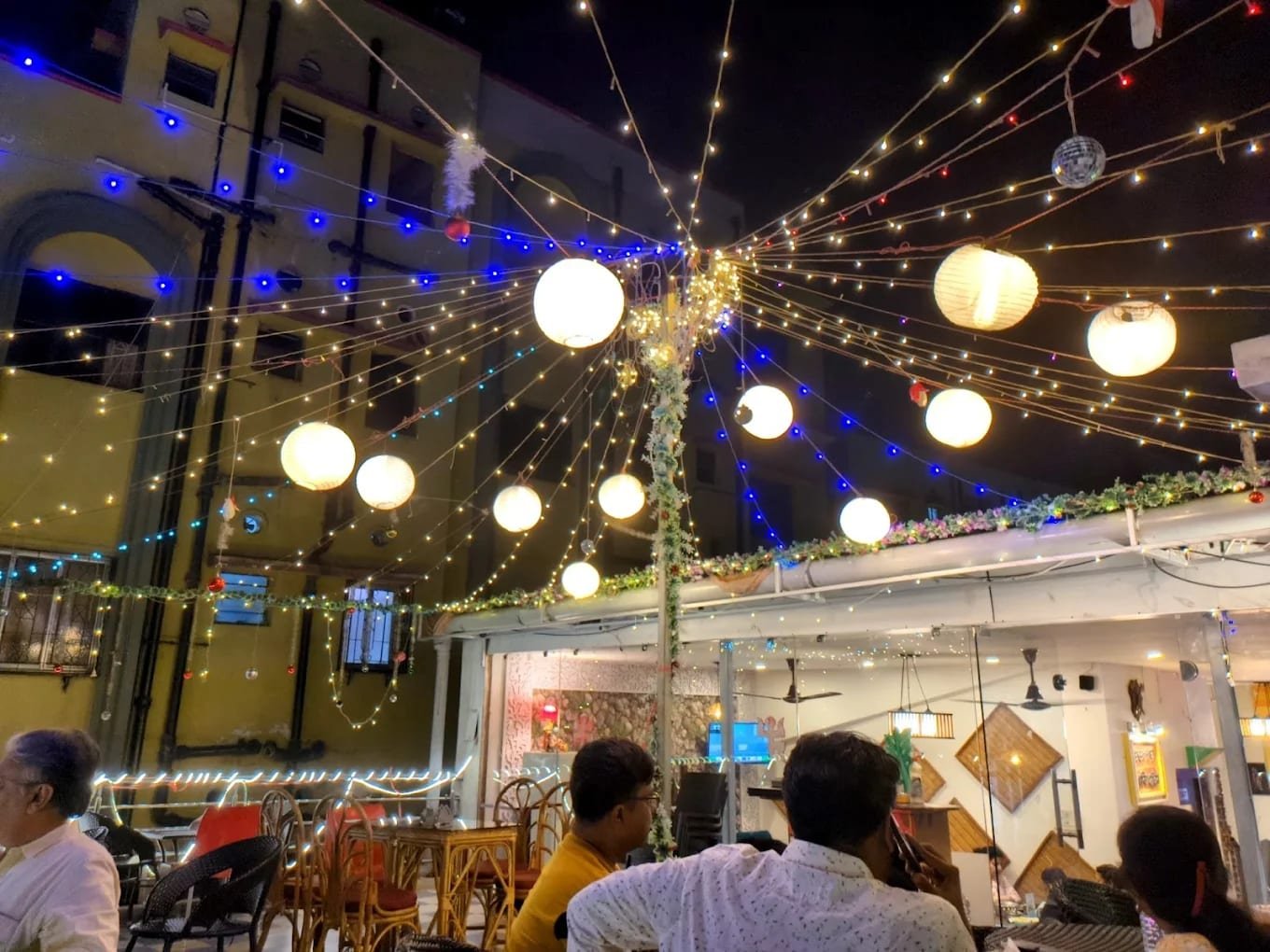 Rooftop lanterns and fairy lights glowing at night