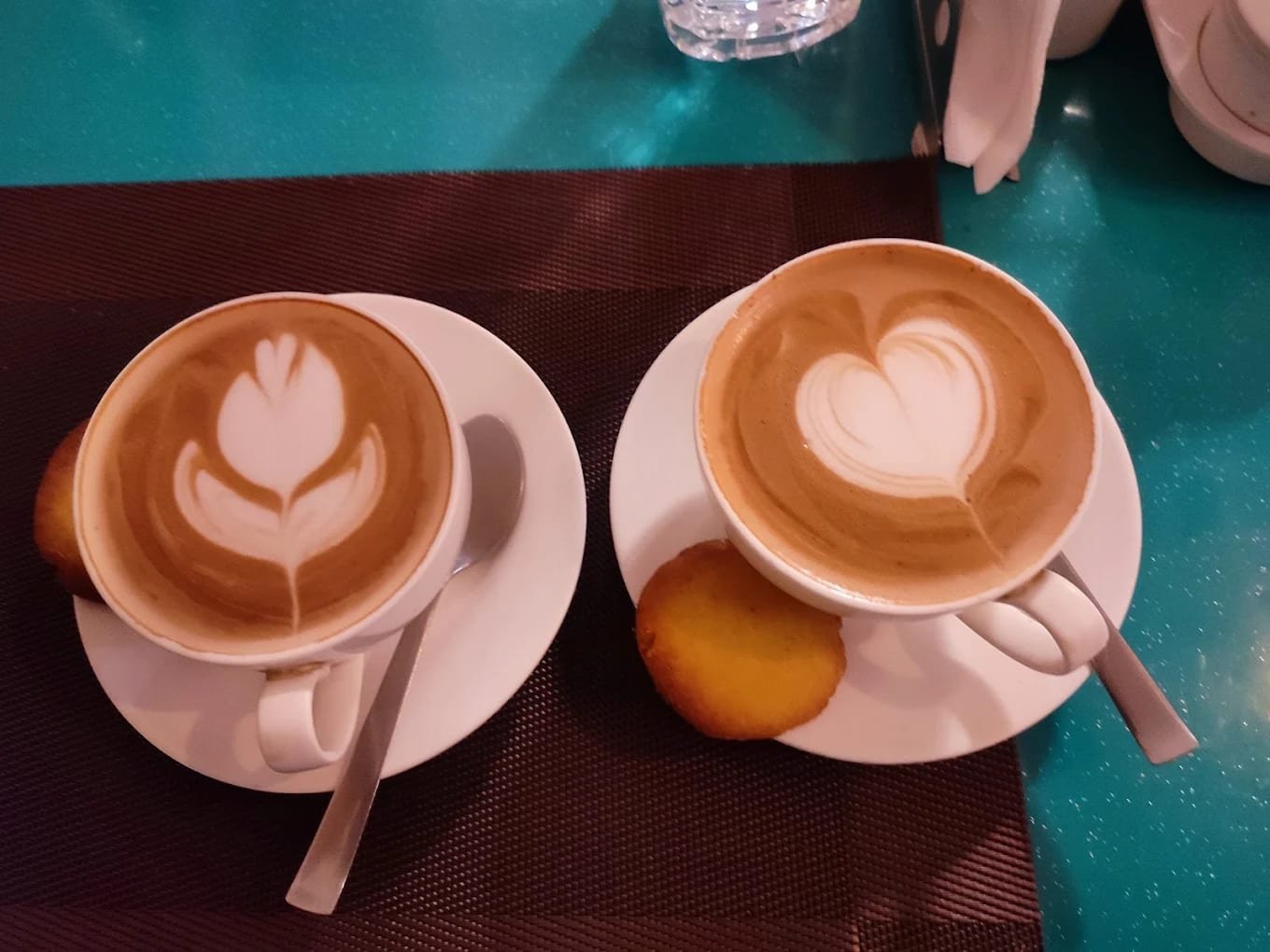Two cappuccinos with rosetta and heart art